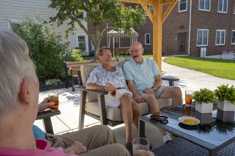 Residents from UZRC sitting under a pavilion while talking and laughing