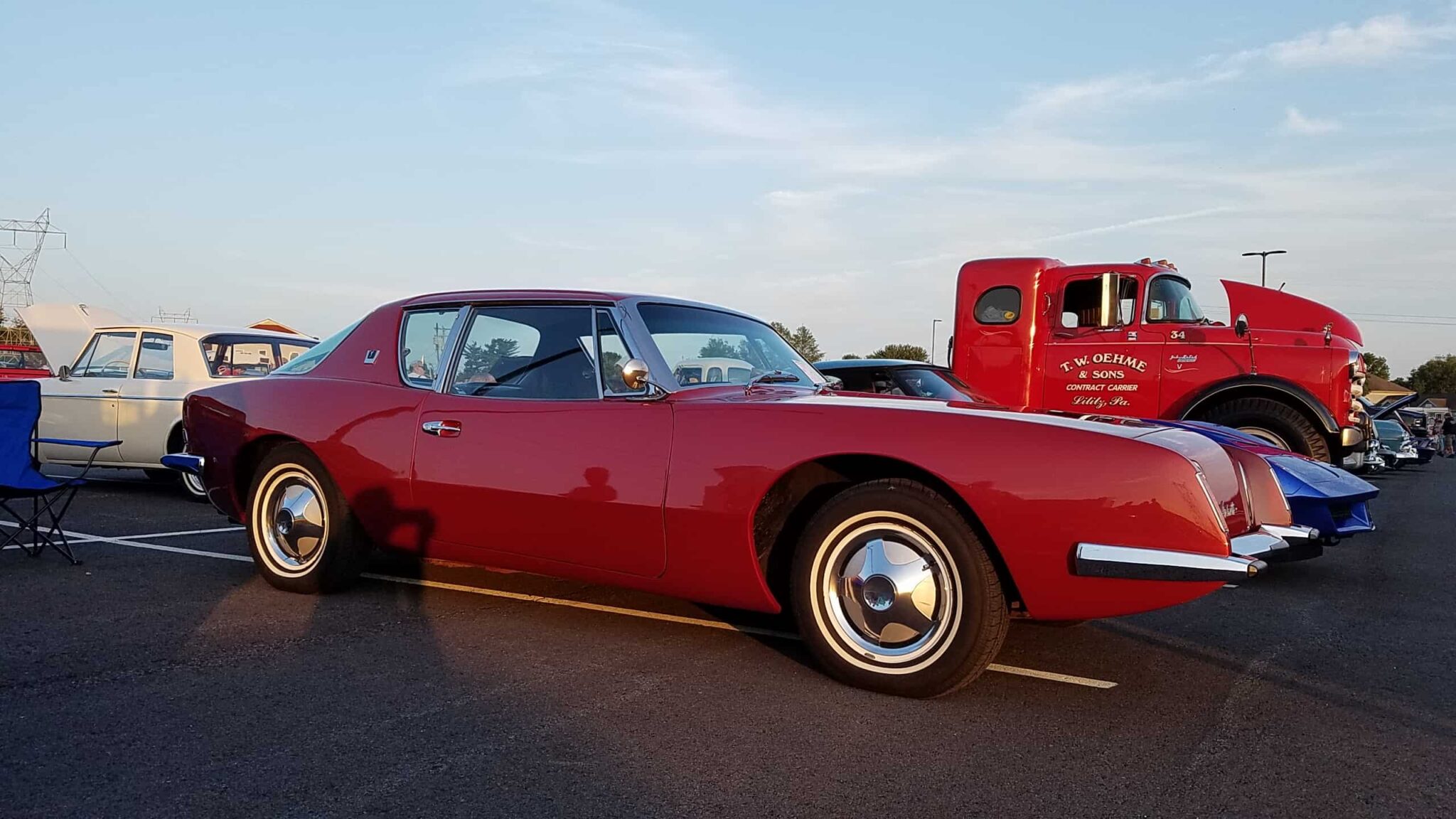 A sleek red sports car with a red truck next to it, both entered into UZRC's 2017 