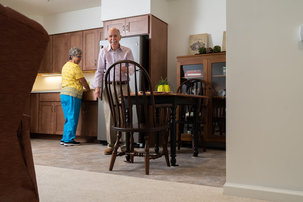 A smiling elderly couple in their cottage that they live in at United Zion Retirement Community.